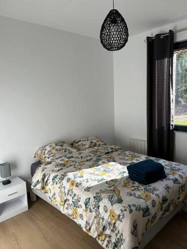 une chambre avec un lit avec une couette dessus dans l'établissement Gites les Amourettes, à Saint-Aubin-sur-Scie