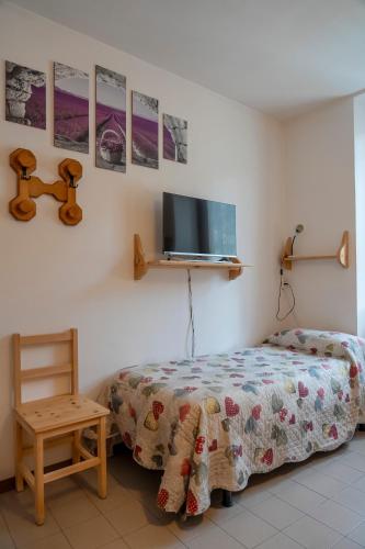 a bedroom with a bed and a tv on the wall at Camere vecchio borgo in Bormio