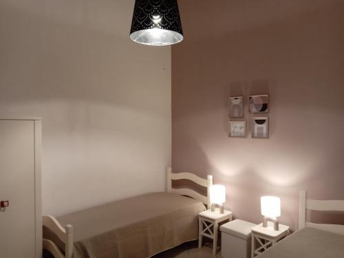 a small bedroom with two beds and two lamps at ARZERIA in Cavallino di Lecce