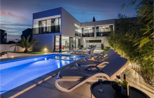una casa con piscina e sedie a sdraio di Villa Mariner a Medulin