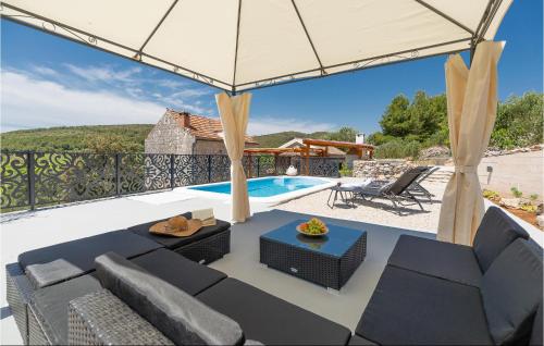 a patio with a couch and chairs and a pool at 2 Bedroom Gorgeous Home In Smokvica in Smokvica