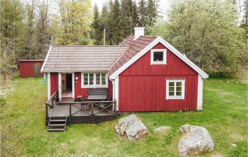 a red house with a deck in a yard at Pet Friendly Home In Ryd With Kitchen in Ryd