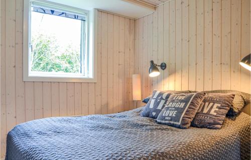 a bedroom with a bed with pillows and a window at Three-Bedroom Holiday Home In Dronningmolle in Dronningmølle
