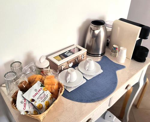 a table with a basket of bread and a coffee maker at Alba b&b in Polignano a Mare