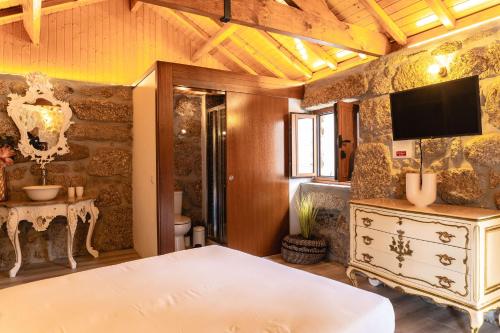 a bedroom with a bed and a tv on a wall at Refúgios da Natureza in Entre -os- Rios