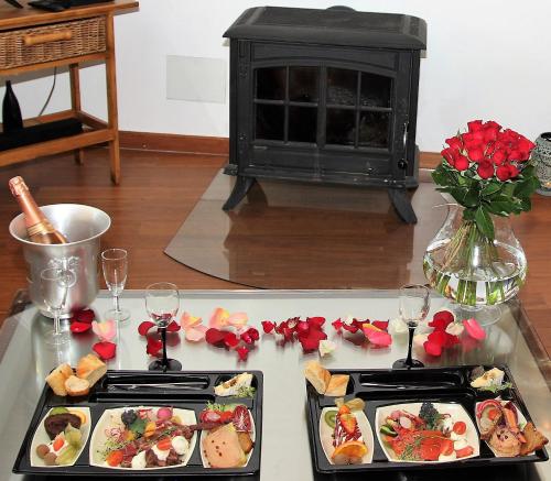 a table with two trays of food and a fireplace at Duo Détente in Le Chenoy