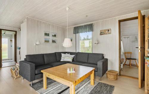 a living room with a couch and a table at Amazing Home In Øster Assels With Wifi in Øster Assels