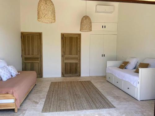 a bedroom with two beds and cabinets and a rug at La canopée, Bastide sur les hauteurs de Lourmarin in Lourmarin