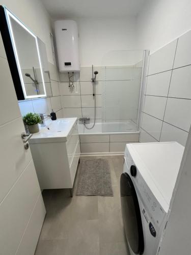 a bathroom with a shower and a sink and a washing machine at Luxury apartment with parking in Graz