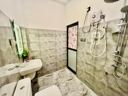 a bathroom with a shower and a sink and a toilet at Bird House Villas in Tangalle