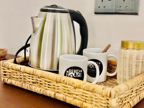 a wicker basket with coffee mugs on a table at Bird House Villas in Tangalle