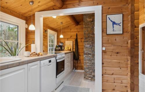 a kitchen with white cabinets and a brick wall at 3 Bedroom Beautiful Home In Hornbæk in Hornbæk