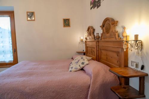 a bedroom with a large bed with a wooden headboard at Camere vecchio borgo in Bormio