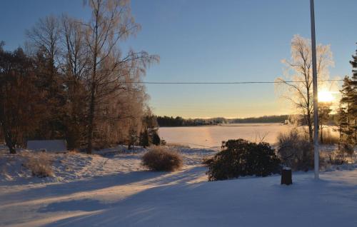 a snow covered field with a river in the background at Amazing Home In Köpmannebro With Wifi in Åsensbruk