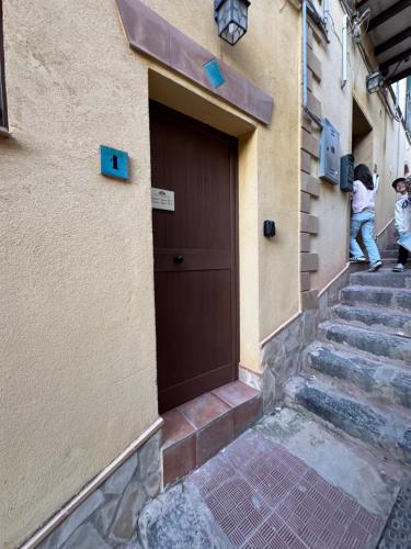 a person standing next to a building with a door at Le Scalette del centro in Agrigento