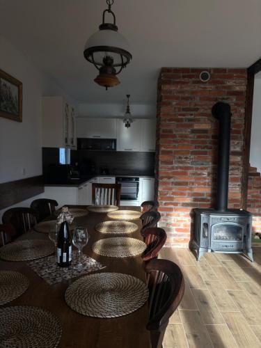 a kitchen with a table with chairs and a fireplace at Hereczówka 2 in Bardo