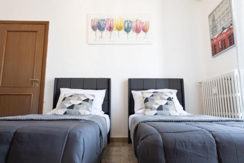 two beds sitting next to each other in a room at Alice Apartments in Rho
