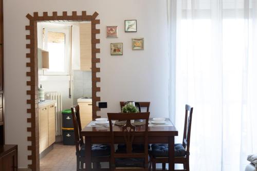 a dining room with a wooden table and chairs at Alice Apartments in Rho