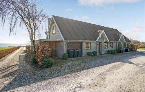 a house with a gambrel roof on a gravel driveway at Gorgeous Home In Øster Assels in Øster Assels