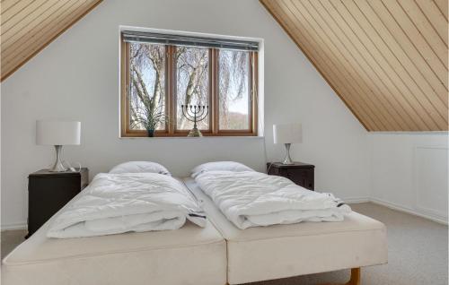 a white bedroom with two beds and a window at Gorgeous Home In Øster Assels in Øster Assels