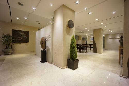 a lobby with a potted plant and a dining room at Hotel Matthieu Yeosu in Yeosu