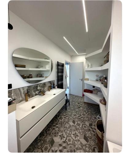 une salle de bain avec un lavabo et un miroir au mur dans l'établissement Chambre confort, à Merpins