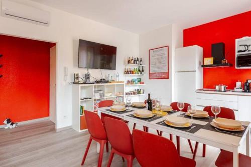 a dining room with a table with chairs and red walls at Boutique Apartment Family in Chiusi