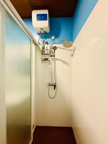 a shower in a bathroom with a blue wall at The Tenthola in Kandy