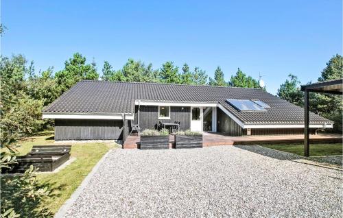 a house with a pitched roof and a gravel driveway at 4 Bedroom Cozy Home In Brovst in Brovst