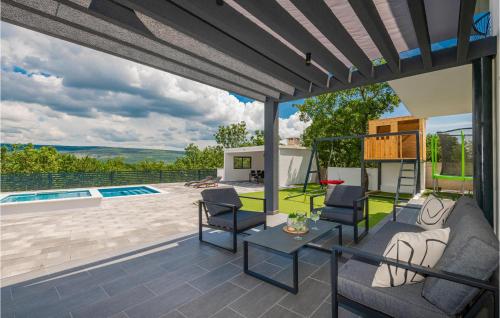 a patio with chairs and a table and a pool at 4 Bedroom Stunning Home In Grubine in Grubine