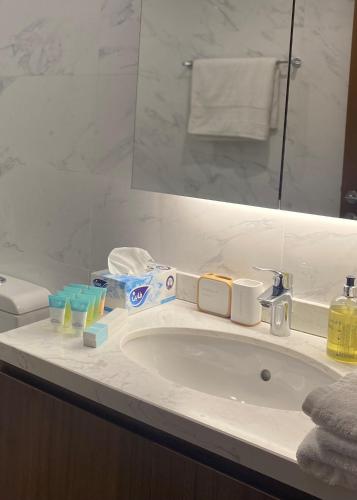 a bathroom counter with a sink and a mirror at Beachfront 2BHK apartment at Al Mouj in Seeb