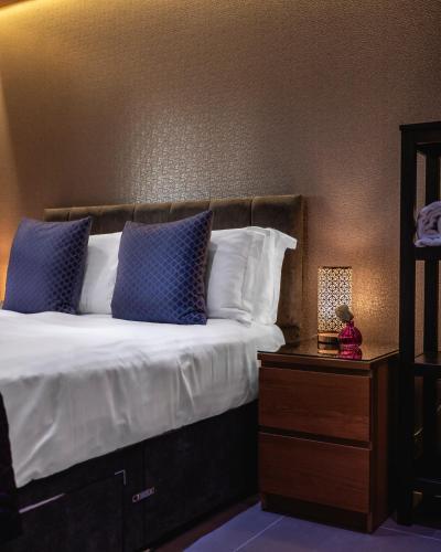 a bedroom with a bed with blue and white pillows at The Retreat Cabin in Pitlochry