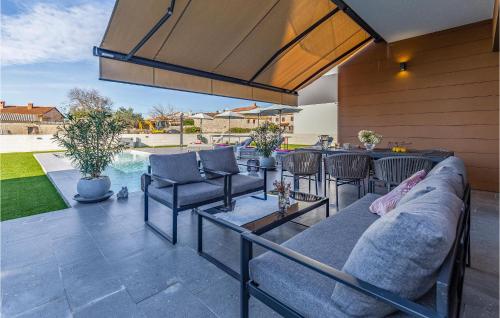 d'une terrasse avec un canapé, des chaises et une table. dans l'établissement 3 Bedroom Awesome Home In Orbanici, à Orbanići