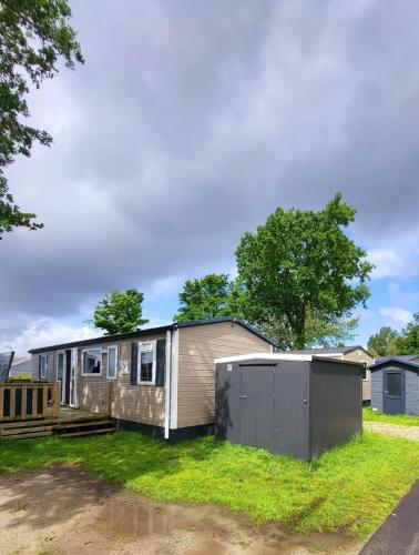 a tiny house sitting on top of a yard at Chalet tussen Zee en Meer in Lauwersoog