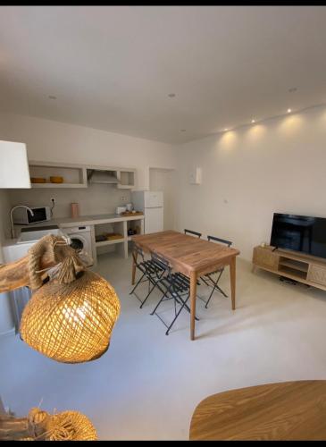 un salon avec une table et une cuisine dans l'établissement Paros appartement salon et chambre, à Nîmes