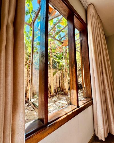 a window in a room looking out at a garden at Pousada Casa das Flores in Sao Jorge