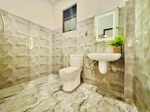 a bathroom with a toilet and a sink at Bird House Villas in Tangalle