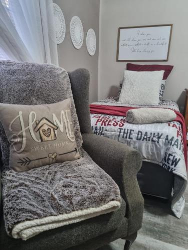a living room with a chair and a throw pillow at Grace B&B in Potchefstroom