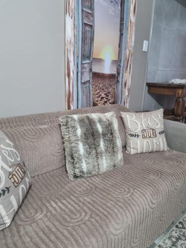a couch with pillows sitting in a living room at Grace B&B in Potchefstroom