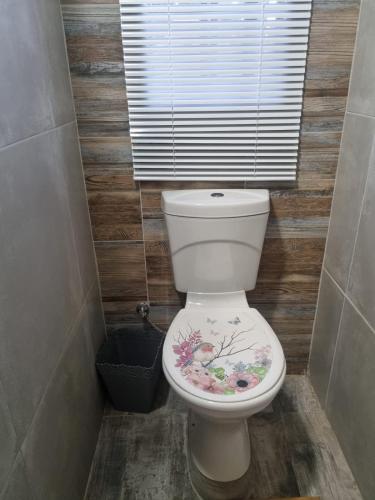 a bathroom with a toilet with a flower painted on it at Grace B&B in Potchefstroom