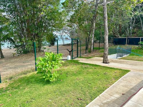 a park with a fence and a tree at Punta Verde Beach Condo in Tarcoles