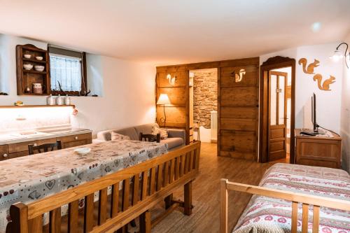 a bedroom with a bed and a living room with at Maison de l'écureuil in Courmayeur