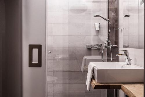 a white bathroom with a sink and a shower at Landhotel Das Stocker in Vorderstoder