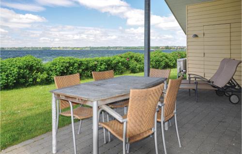 a table and chairs on a patio with a view of the water at Marina Minde in Rendbjerg