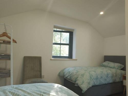 ein Schlafzimmer mit einem Bett und einem Stuhl und einem Fenster in der Unterkunft The Bath House & Sauna Garden x 4 beds in Newcastle