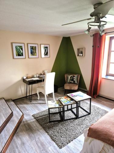 un salon avec un mur vert et une table dans l'établissement Au Lavoir du Serein 