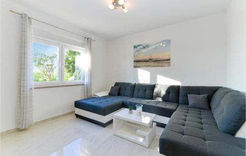 a living room with a blue couch and a table at Cozy Home In Rovanjska in Rovanjska