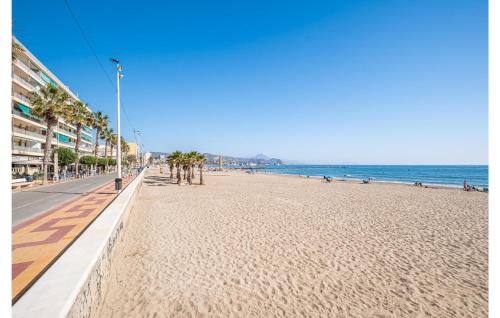 einen Sandstrand mit Palmen und dem Meer in der Unterkunft Beautiful Apartment In El Campello in El Campello