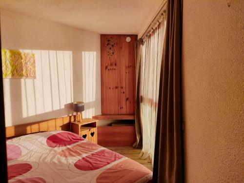 Un dormitorio con una cama y una ventana en F2 front de neige la Rosière, en La Rosière