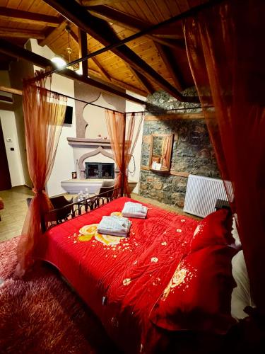 a large red bed in a room with a fireplace at Guesthouse Nifada tou Vorra in Palaios Agios Athanasios